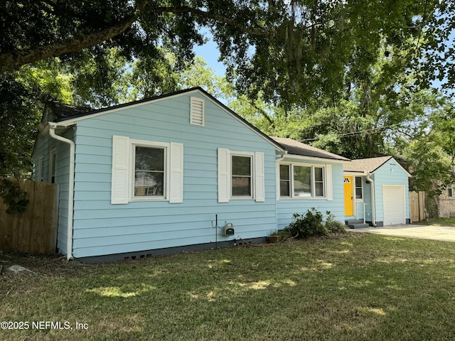 ranch-style home with a front yard, a garage, concrete driveway, and fence