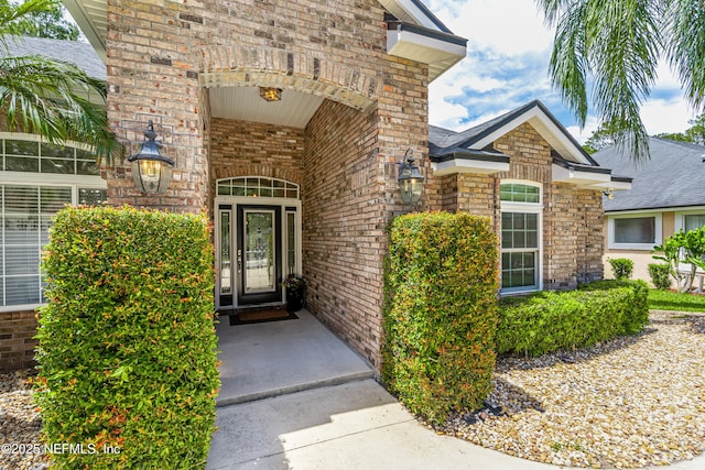 view of exterior entry featuring brick siding