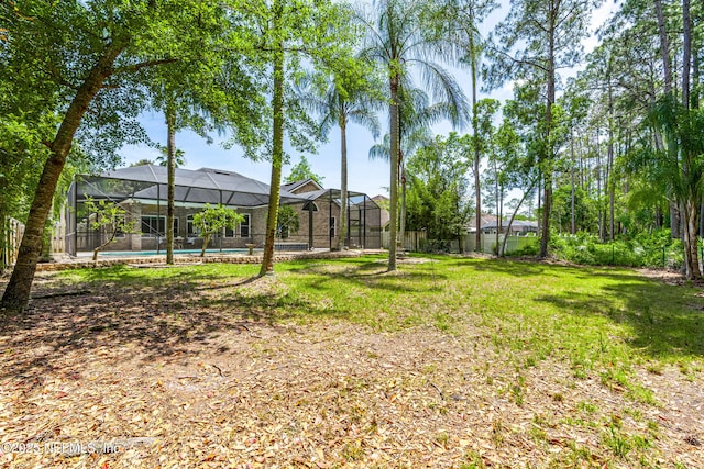 view of yard with glass enclosure, a fenced backyard, and an outdoor pool