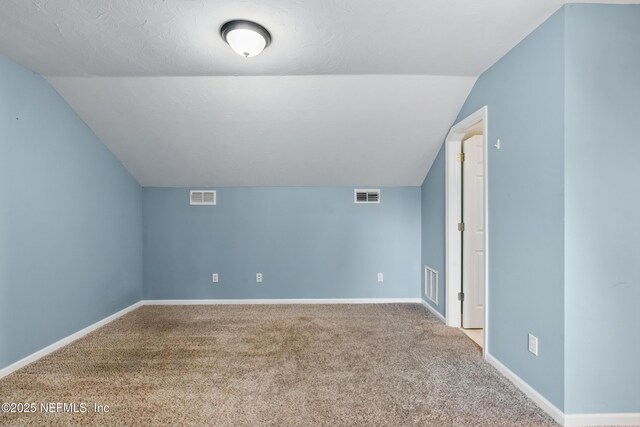 bonus room with visible vents, carpet, and vaulted ceiling