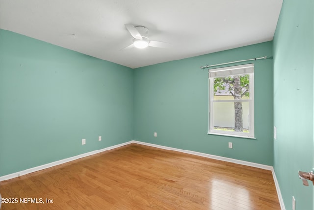 empty room featuring baseboards, ceiling fan, and wood finished floors