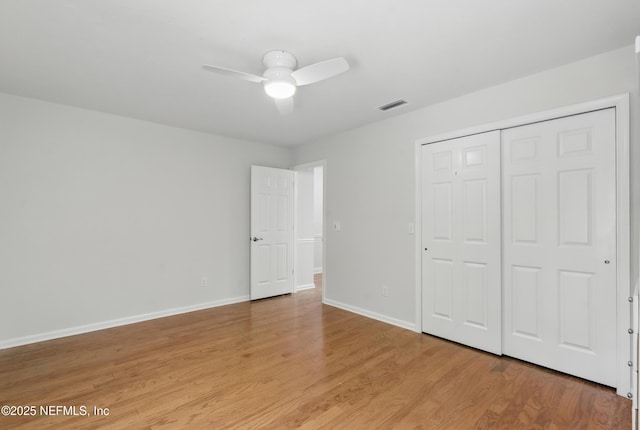 unfurnished bedroom featuring light wood finished floors, a ceiling fan, baseboards, visible vents, and a closet