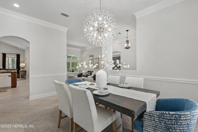 dining area with crown molding, arched walkways, visible vents, and a chandelier