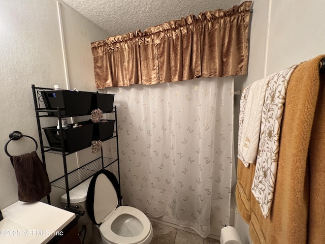 bathroom with tile patterned floors, toilet, a textured ceiling, and a shower with curtain