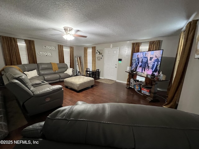 living room featuring baseboards, wood finished floors, a ceiling fan, and a textured ceiling