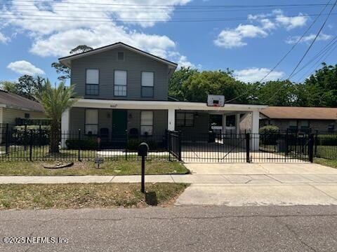 traditional-style home with covered porch, a gate, a fenced front yard, and driveway