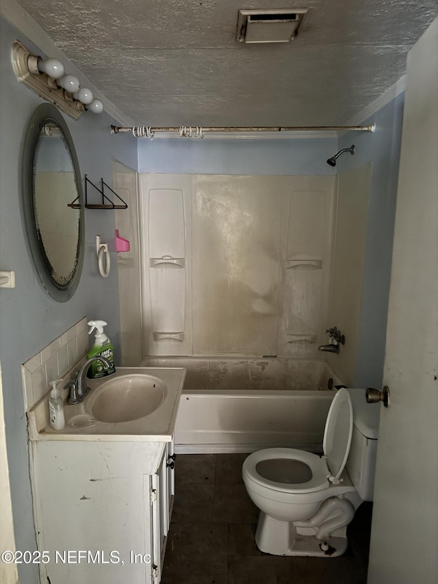 bathroom featuring vanity, shower / bath combination, toilet, a textured ceiling, and tile patterned flooring