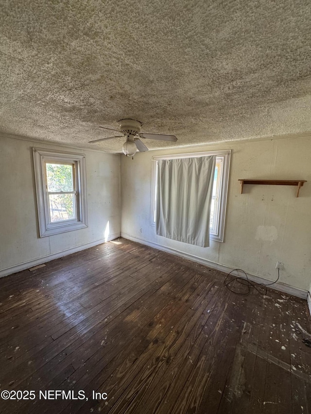 unfurnished room with ceiling fan, visible vents, baseboards, a textured ceiling, and hardwood / wood-style flooring