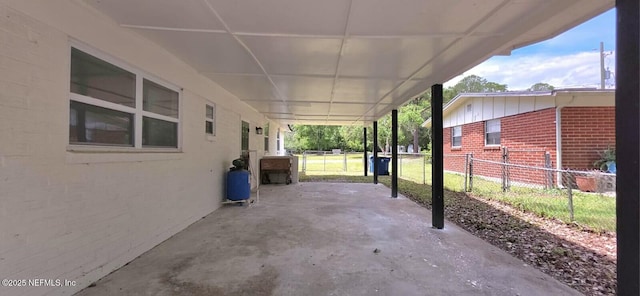 view of patio / terrace featuring fence and a carport