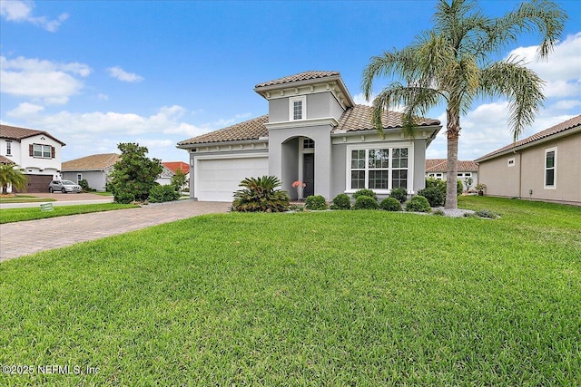mediterranean / spanish-style house featuring a front lawn, a garage, decorative driveway, a tiled roof, and stucco siding