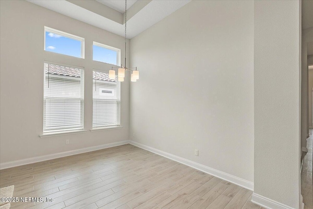 unfurnished room with light wood-type flooring and baseboards