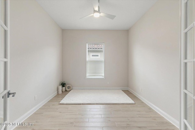 unfurnished room with light wood-style floors, ceiling fan, and baseboards