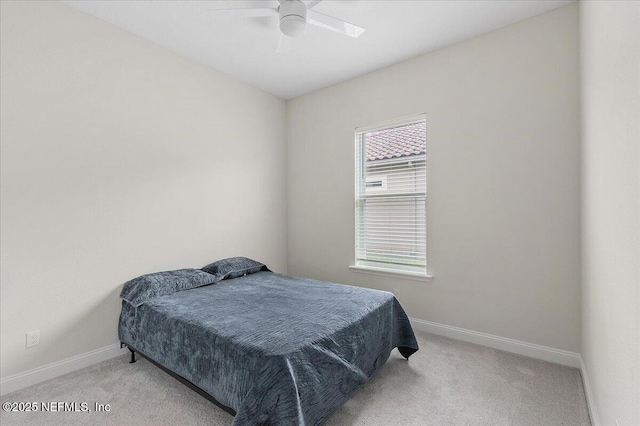 bedroom with ceiling fan, light colored carpet, and baseboards