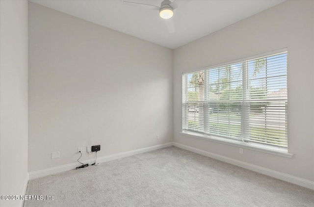 carpeted empty room with baseboards and a ceiling fan