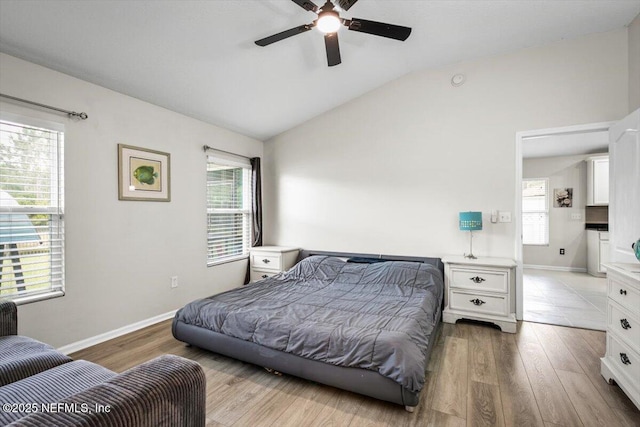 bedroom with light wood-type flooring, baseboards, ceiling fan, and vaulted ceiling
