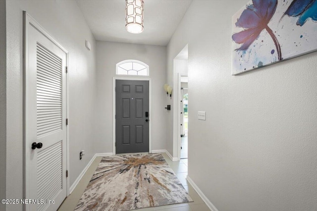 entrance foyer featuring baseboards and tile patterned flooring