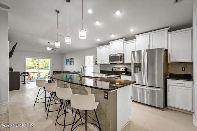 kitchen featuring a sink, a ceiling fan, a wealth of natural light, and stainless steel appliances