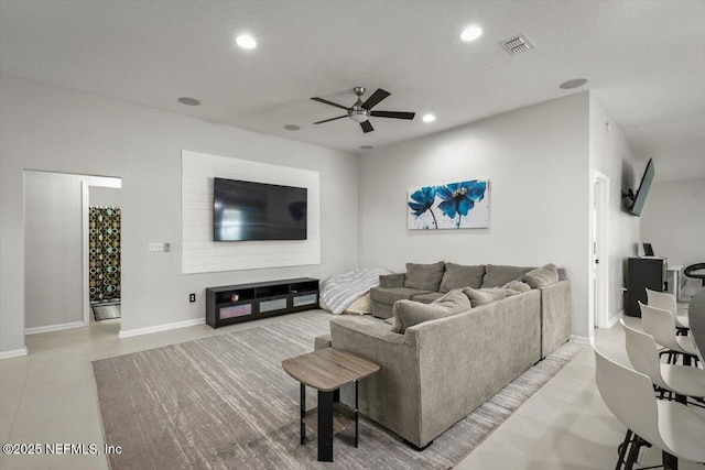 living room with a ceiling fan, visible vents, baseboards, tile patterned floors, and recessed lighting
