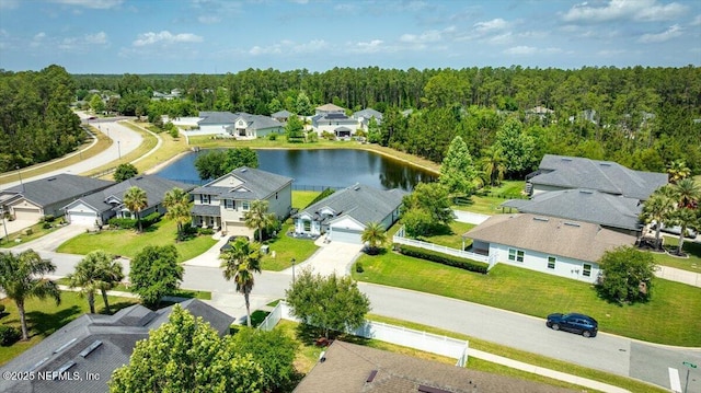 aerial view with a water view, a view of trees, and a residential view