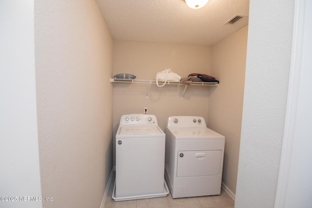 11213 Minnetta Ct, Jacksonville, FL 32256 - laundry area featuring a textured ceiling, visible vents, baseboards, separate washer and dryer, and laundry area