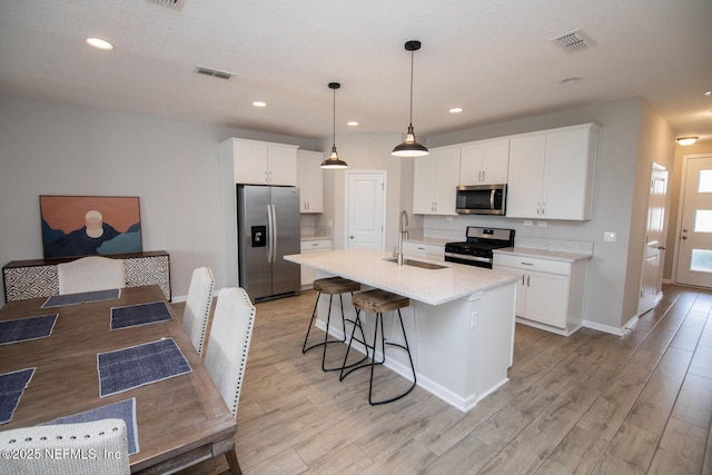 11213 Minnetta Ct, Jacksonville, FL 32256 - kitchen featuring visible vents, stainless steel appliances, light wood-type flooring, and a sink