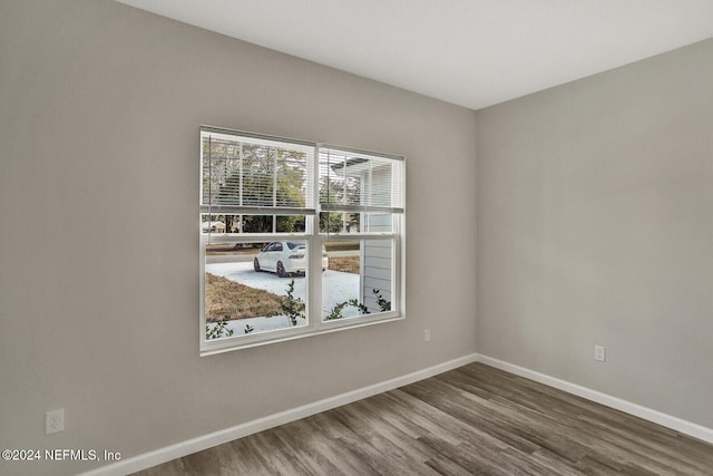 spare room featuring wood finished floors and baseboards