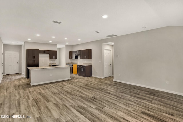 unfurnished living room featuring recessed lighting, a sink, wood finished floors, and baseboards