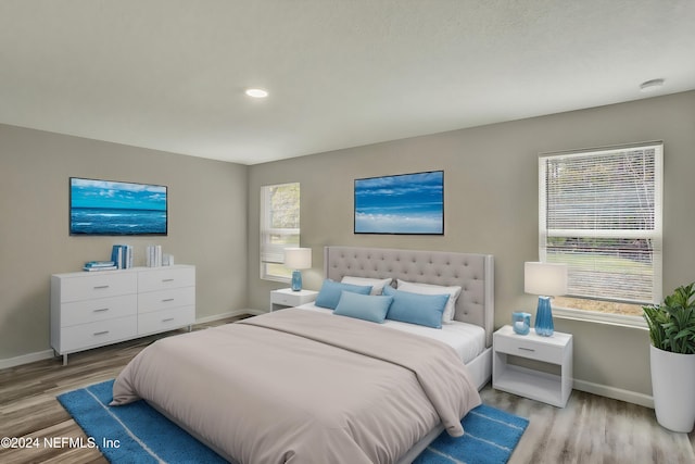 bedroom with recessed lighting, wood finished floors, and baseboards