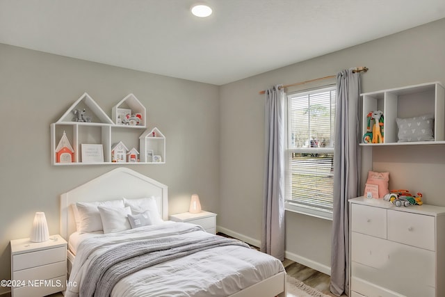 bedroom with light wood finished floors and baseboards