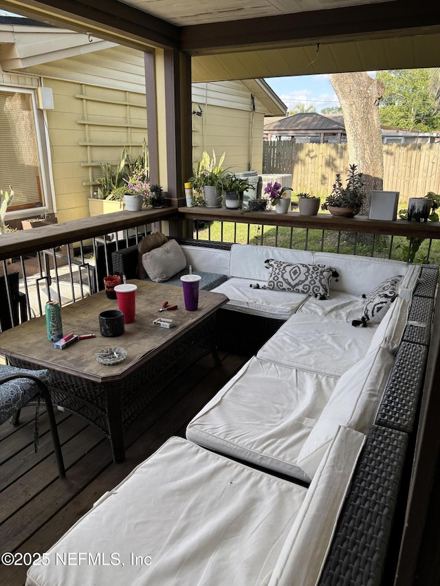 exterior space featuring fence, an outdoor hangout area, and a wooden deck