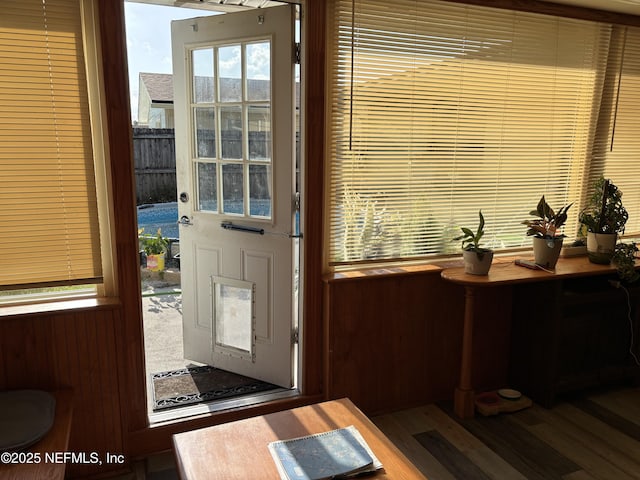 doorway featuring wood walls and wood finished floors