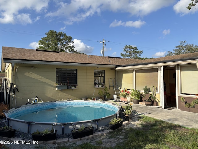 rear view of property with an outdoor pool