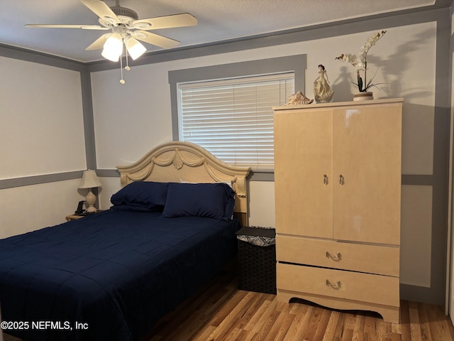 bedroom with wood finished floors and a ceiling fan