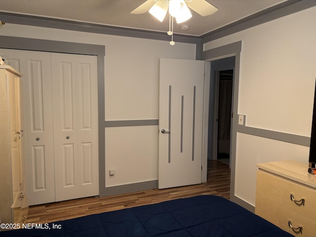 bedroom with a closet, a ceiling fan, and wood finished floors