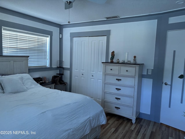 bedroom featuring a closet, visible vents, a ceiling fan, and dark wood finished floors