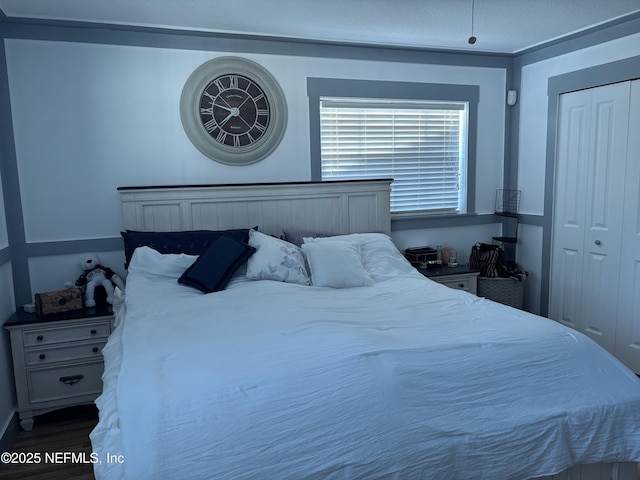 bedroom with wood finished floors and a closet