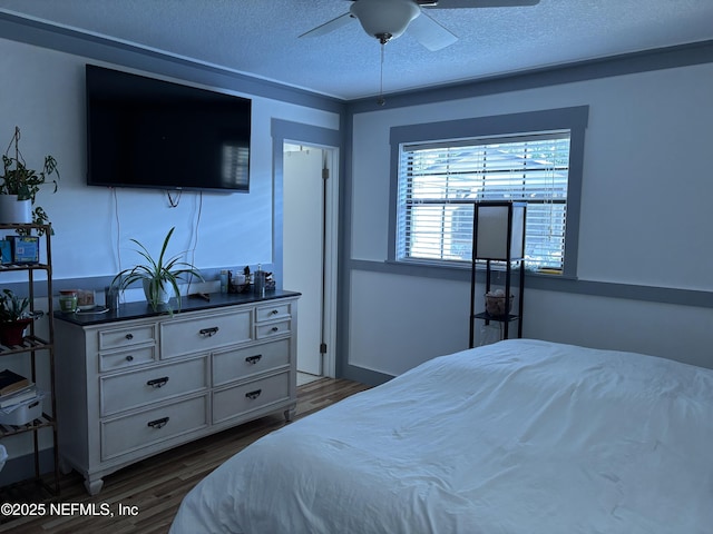 bedroom featuring a textured ceiling, wood finished floors, and a ceiling fan