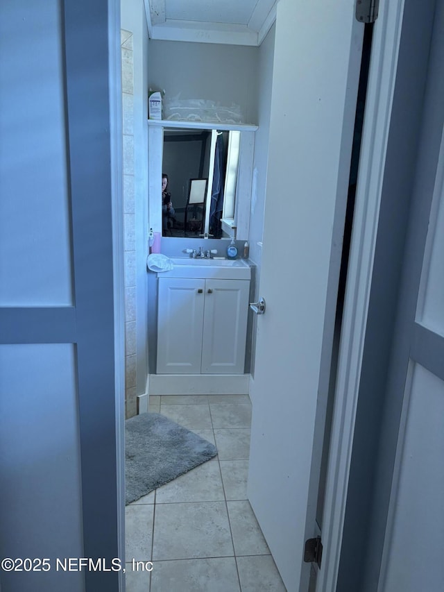 bathroom featuring crown molding, tile patterned flooring, and vanity