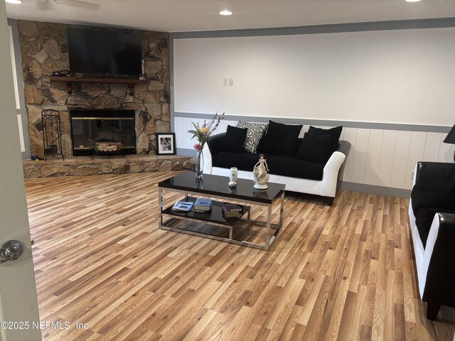 6050 Carrevero Dr S, Jacksonville, FL 32216 - living room featuring wood finished floors, a wainscoted wall, and a stone fireplace