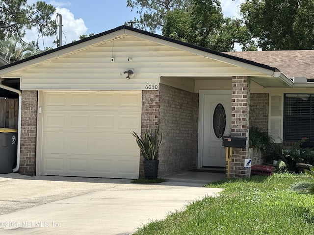 6050 Carrevero Dr S, Jacksonville, FL 32216 - ranch-style home featuring brick siding, concrete driveway, an attached garage, and a shingled roof