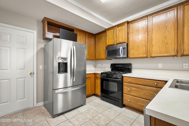 1821 Enterprise Ave, Saint Augustine, FL 32092 - kitchen featuring stainless steel appliances, brown cabinets, light tile patterned floors, light countertops, and a textured ceiling