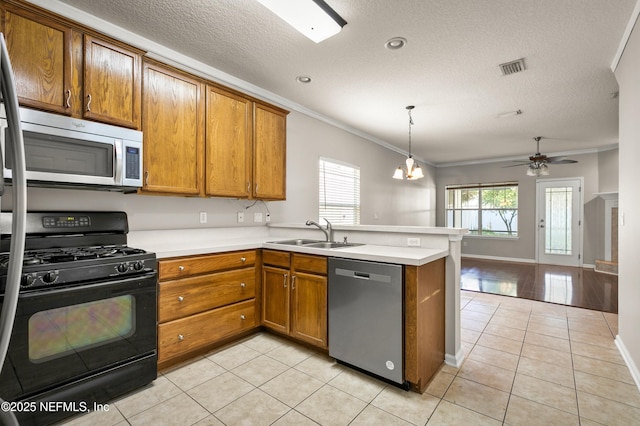1821 Enterprise Ave, Saint Augustine, FL 32092 - kitchen with appliances with stainless steel finishes, a sink, a peninsula, brown cabinets, and light tile patterned flooring