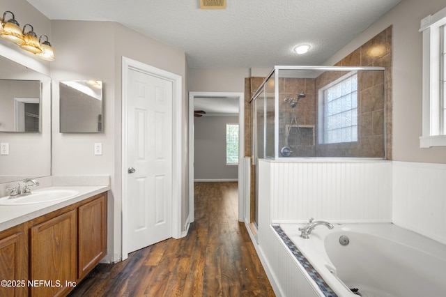 1821 Enterprise Ave, Saint Augustine, FL 32092 - full bathroom with a shower stall, a textured ceiling, a garden tub, wood finished floors, and vanity