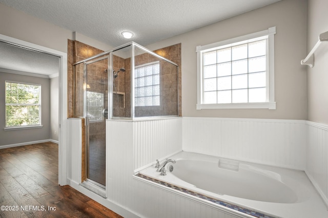 1821 Enterprise Ave, Saint Augustine, FL 32092 - full bath featuring a textured ceiling, a stall shower, wood finished floors, a garden tub, and wainscoting
