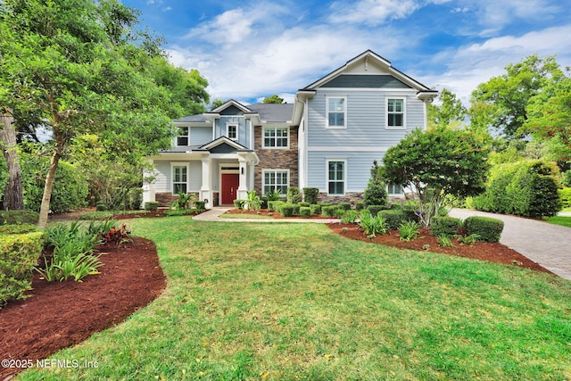 craftsman house featuring a front lawn and stone siding