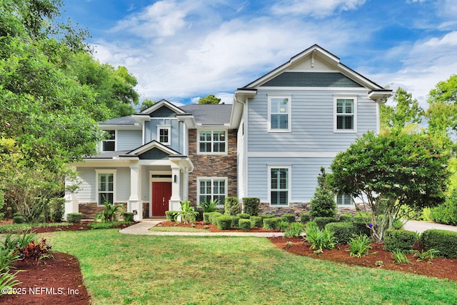 craftsman house with a front yard and stone siding