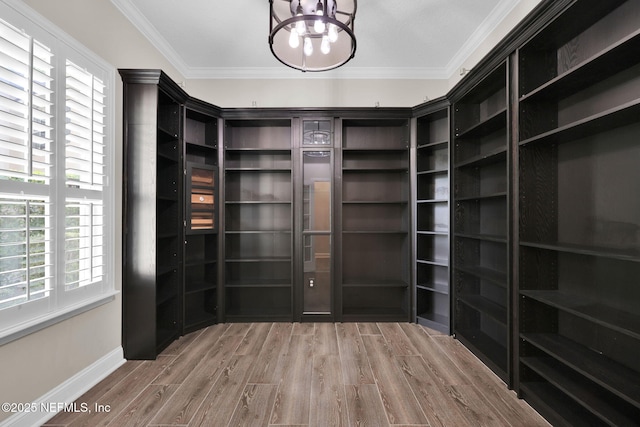 spacious closet featuring wood finished floors and a notable chandelier