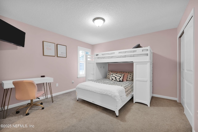 carpeted bedroom featuring a textured ceiling, a closet, and baseboards