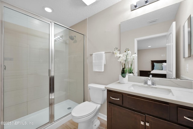 ensuite bathroom with toilet, vanity, ensuite bathroom, and a shower stall