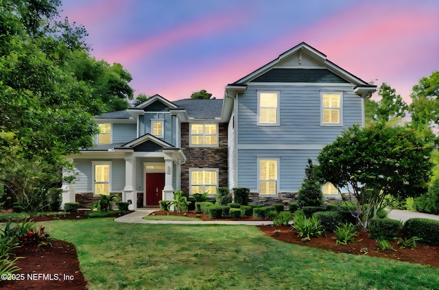 view of front of home featuring a yard and stone siding
